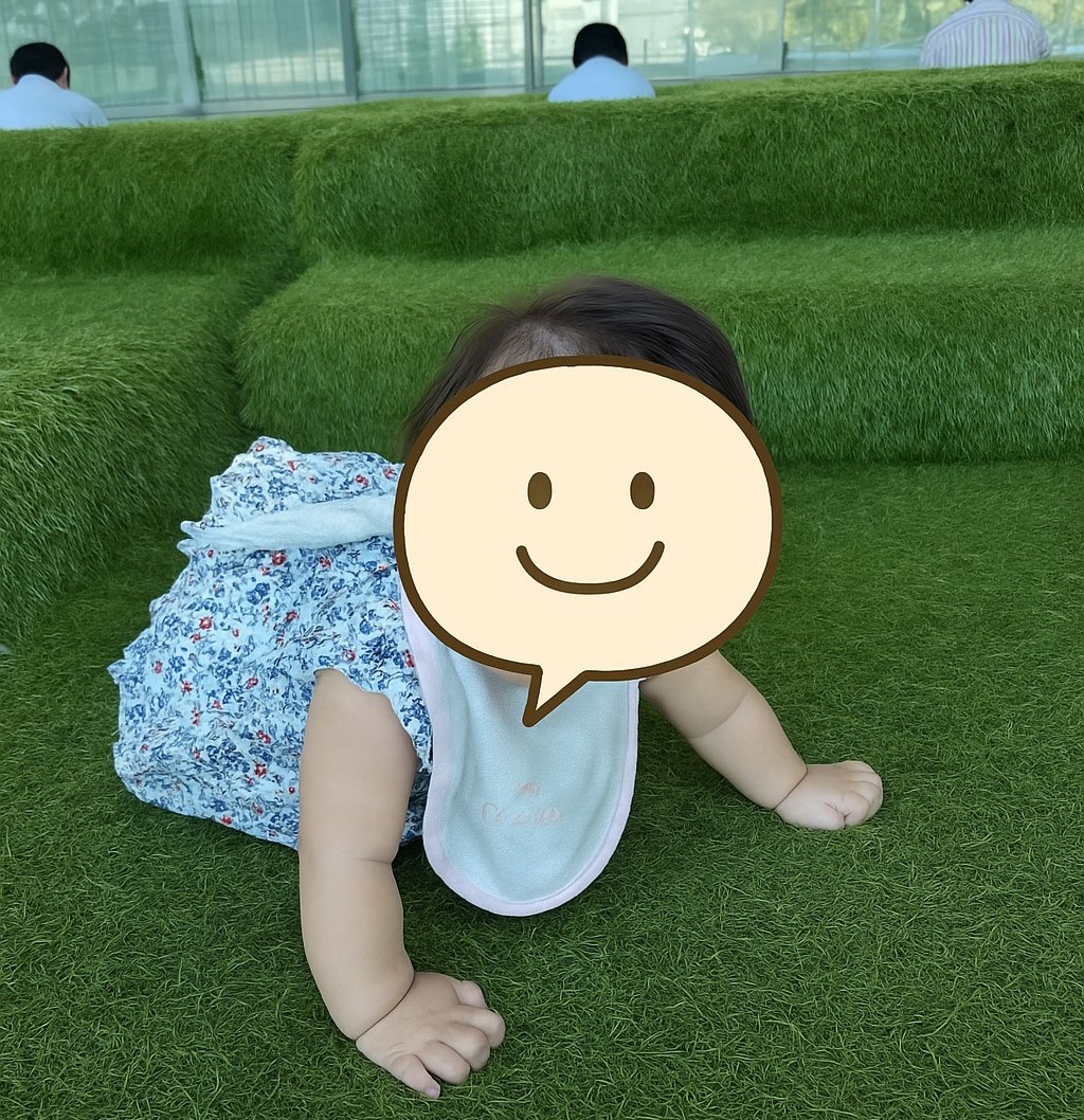 高輪ゲートウェイ駅の芝生風スペースでハイハイする赤ちゃん